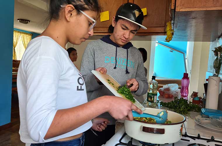 En flicka och pojke hjälps åt att hälla i chili stekapannan