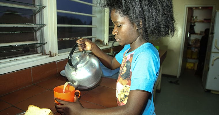 flicka i blå tröja häller upp te