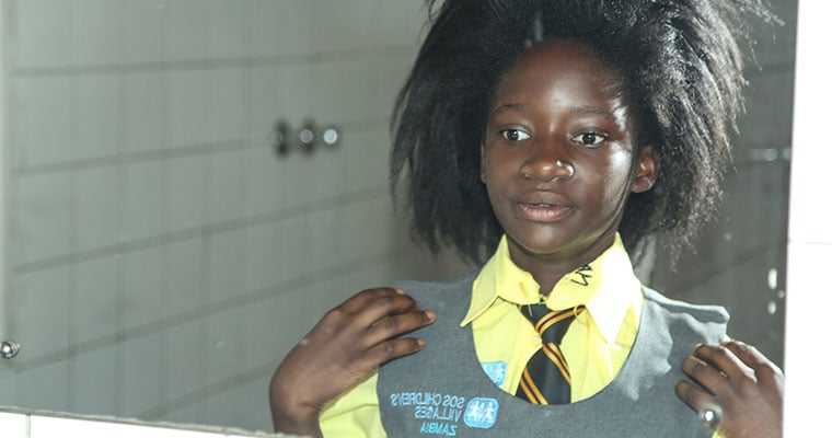 flicka i skoluniform tittar i spegel