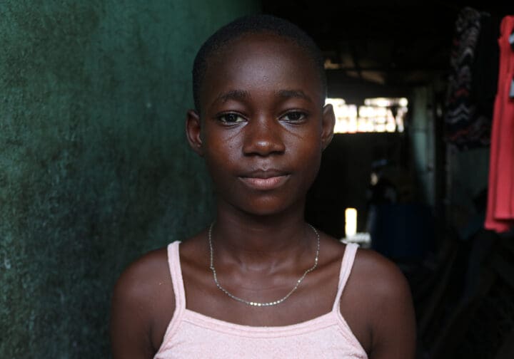 Flicka med allvarlig blick tittar rakt i kameran